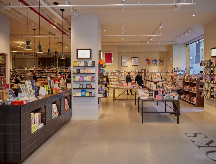 Bright modern bookshop interior with low shelves and display tables.
