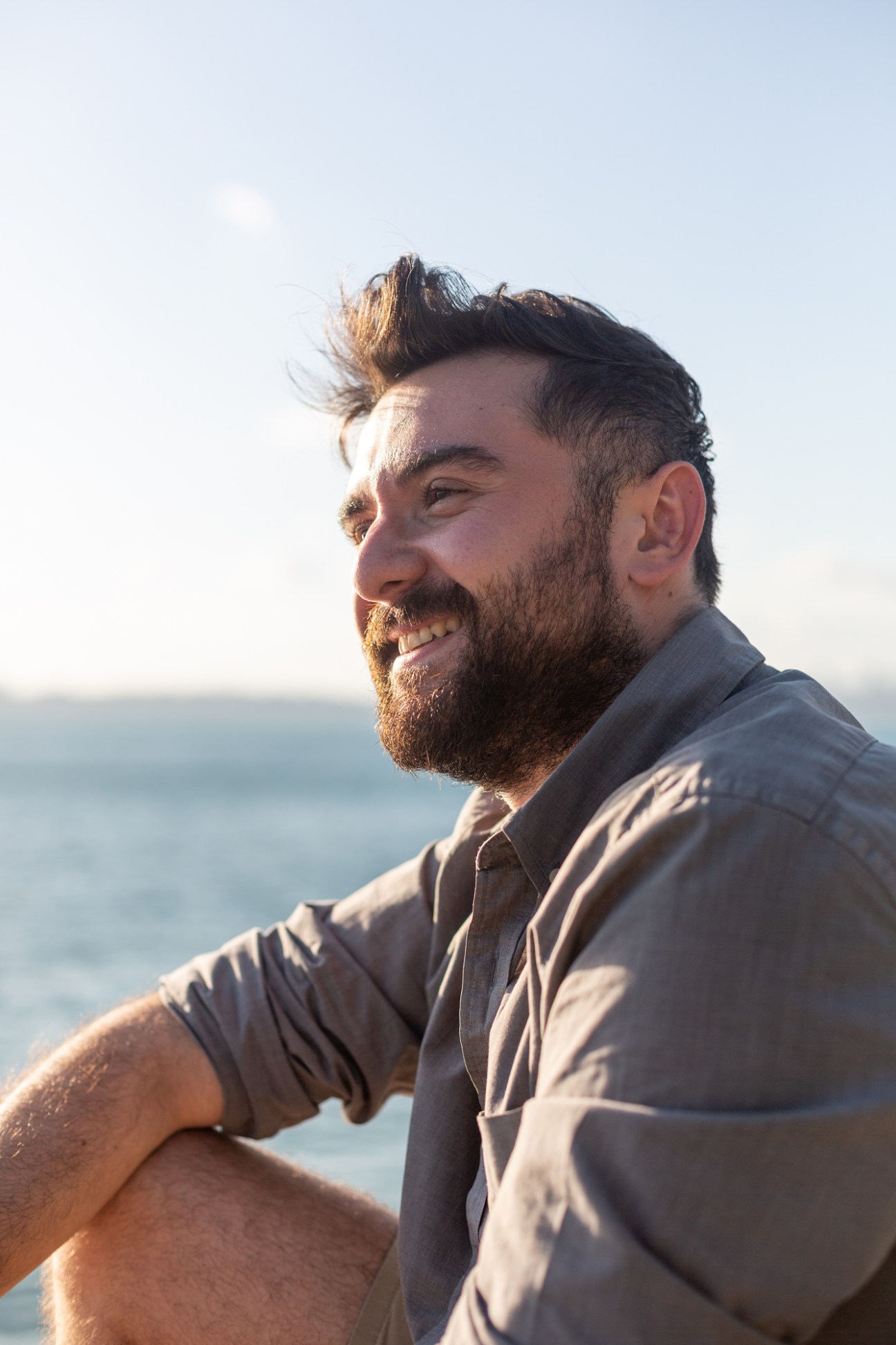 Portrait of journalist Engin Onder in casual attire, standing against an urban backdrop