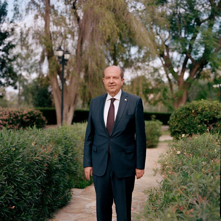 Ersin Tatar, president of the Turkish Republic of Northern Cyprus, standing in formal suit in garden setting