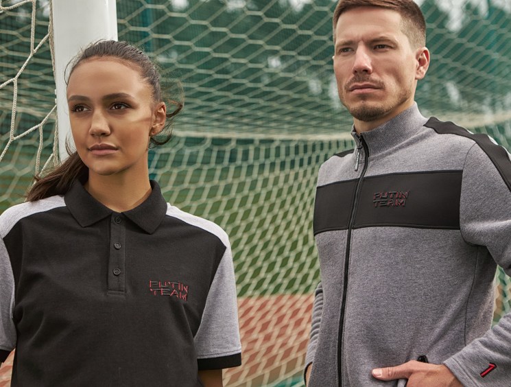 Two models wearing Putin Team Russia branded sportswear posing in front of a soccer goal net