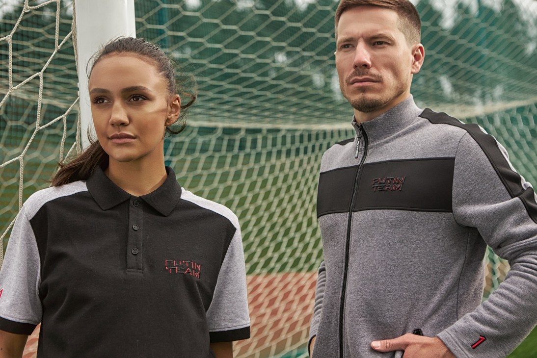 Two models wearing Putin Team Russia branded sportswear posing in front of a soccer goal net