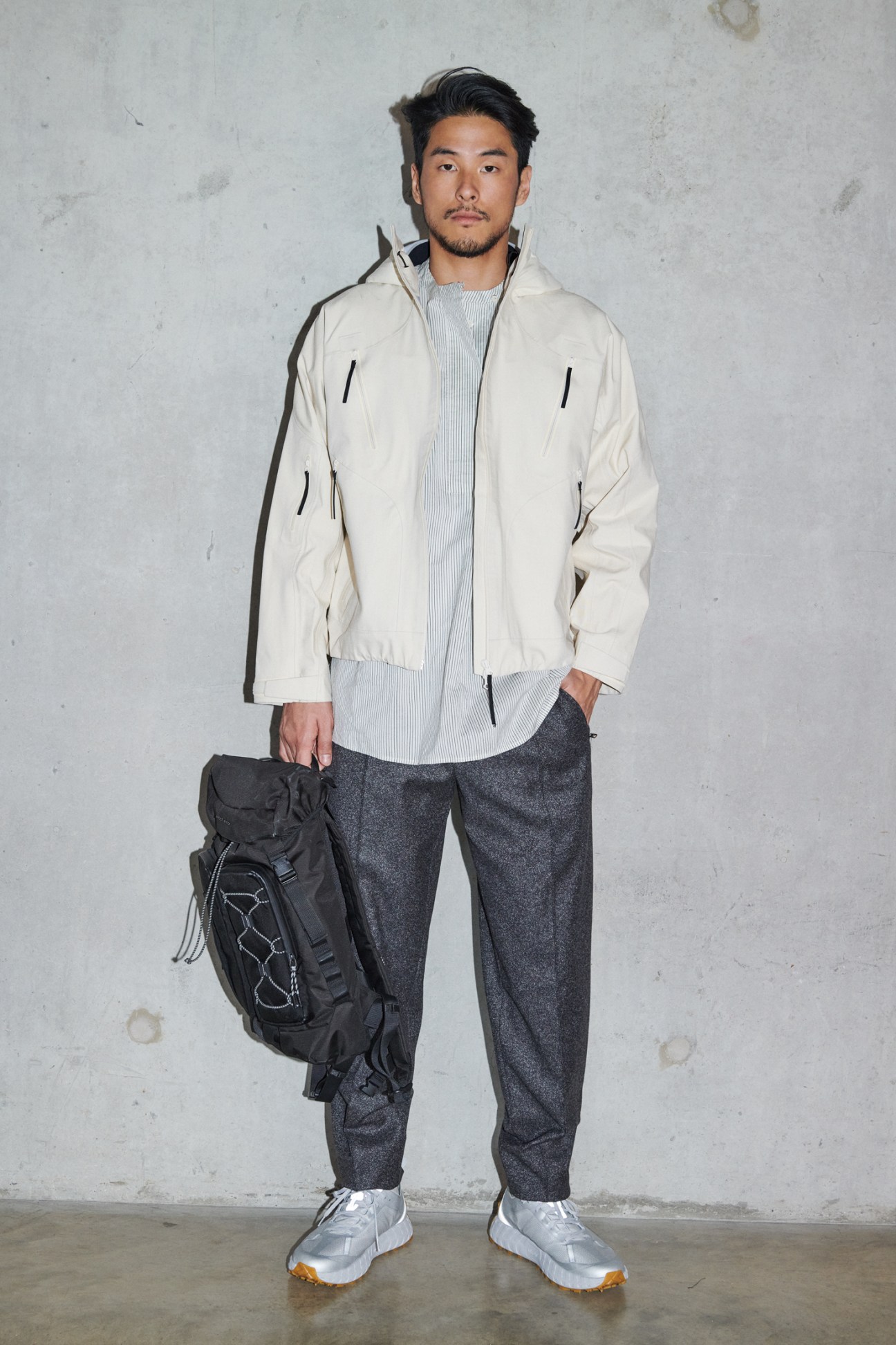 Man in technical jacket with backpack in modern styling