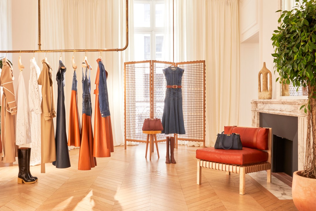 Interior of Chloé boutique showing Otzi leather-bound furniture pieces including chairs and tables in natural wood