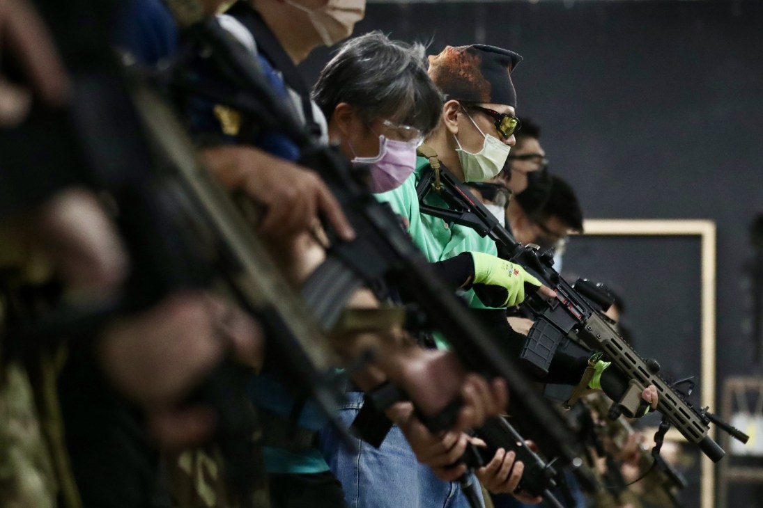 Civilians in protective gear holding rifles during a gun training session in New Taipei City.