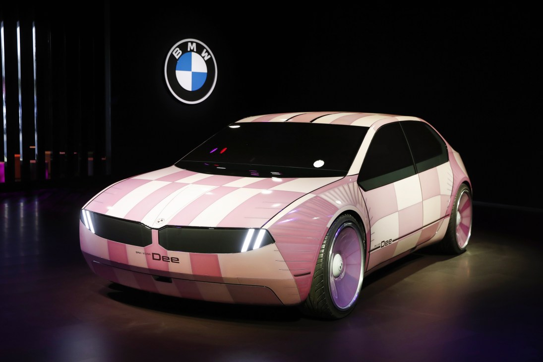 BMW i Vision Dee concept car with pink and white geometric pattern displayed at electronics show