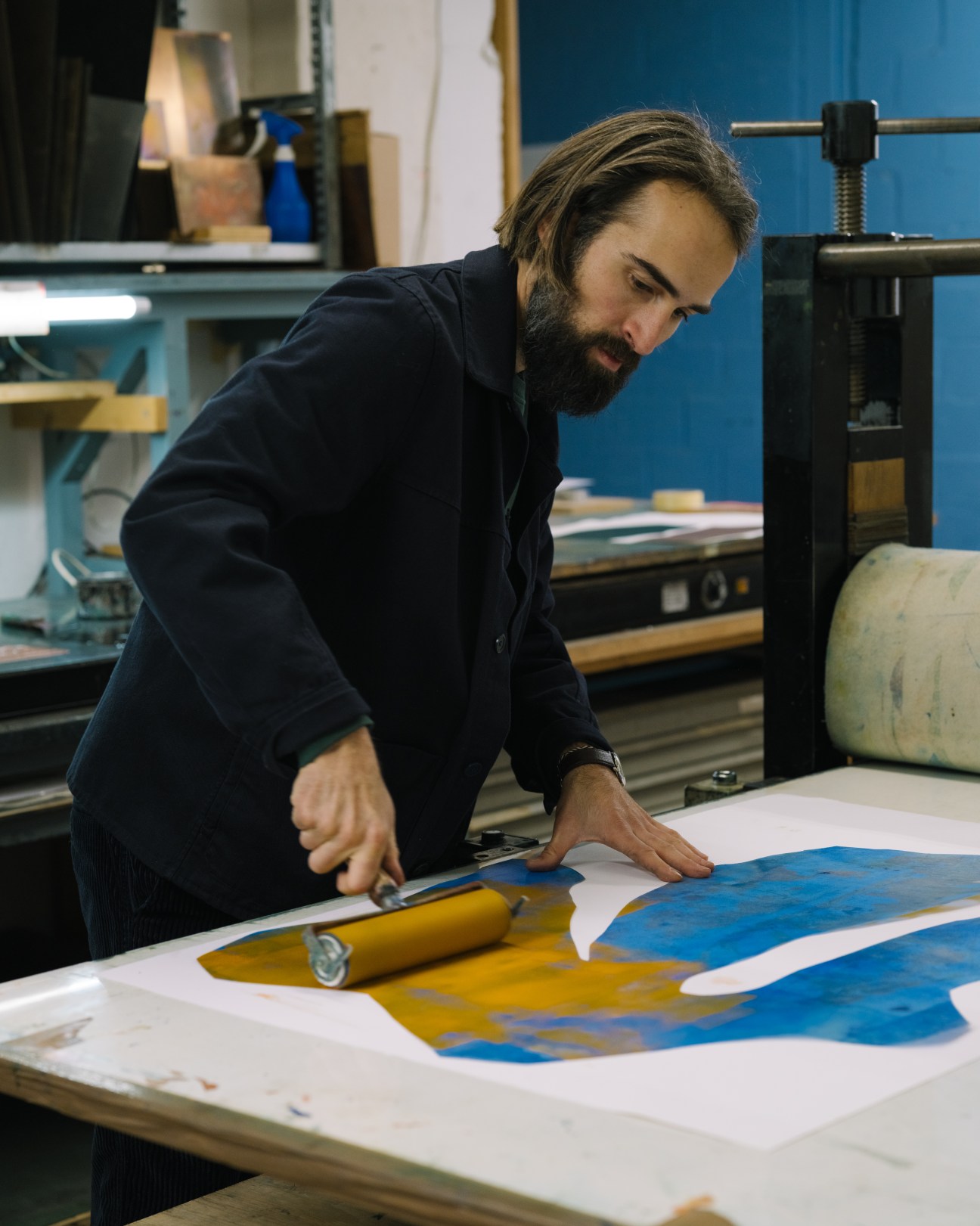Swiss artist Simon Heusser mixing orange paint with a spatula in his Zürich atelier