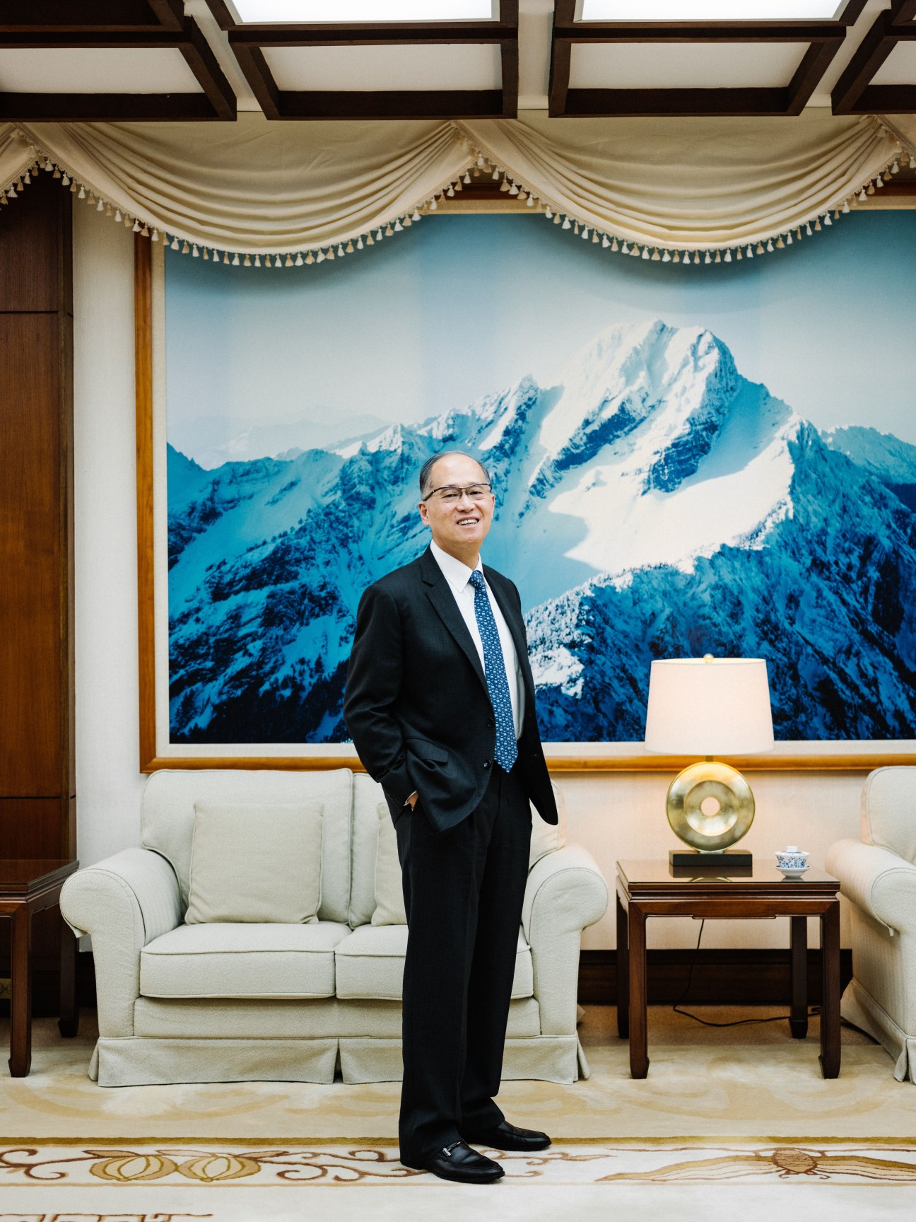 David Lee, Taiwan's foreign minister, standing in formal office setting with snowy mountain backdrop.