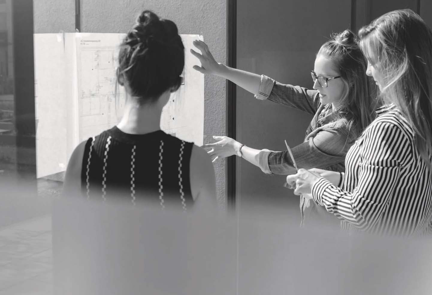 Three people looking at a document in a meeting