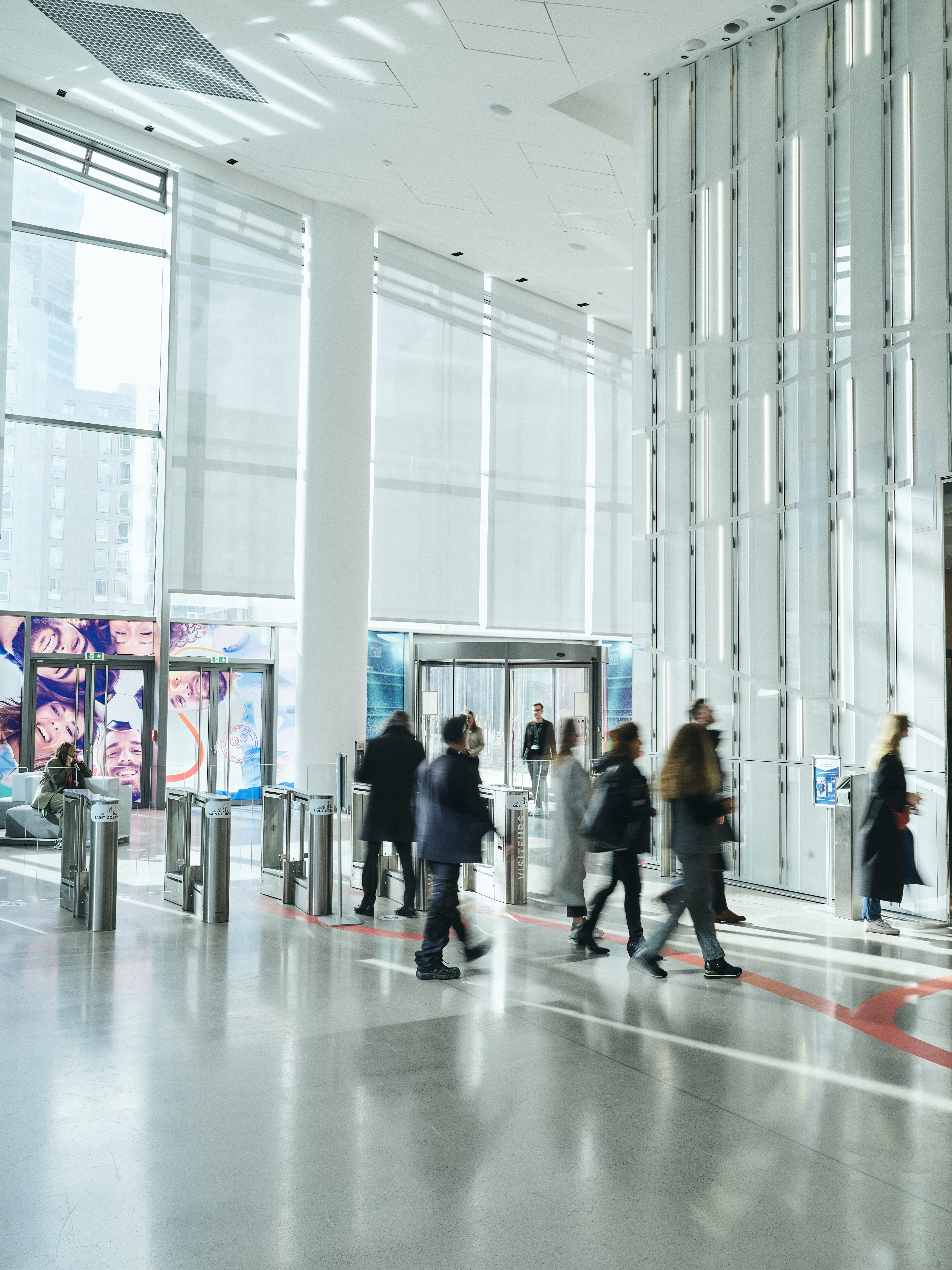 Employees come together in the bright, light foyer of Saint-Gobain Tower in Paris.
