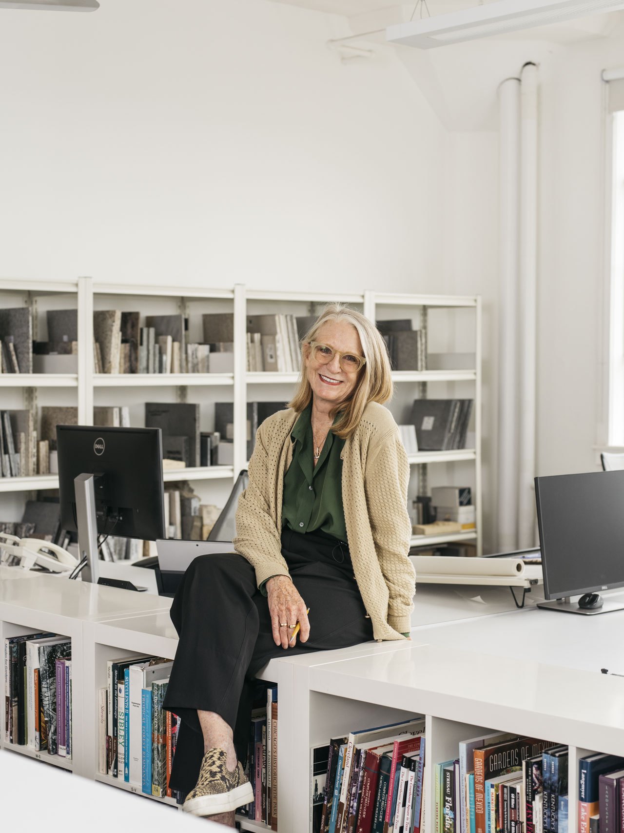 Kathryn Gustafson, landscape architect and co-founder of GGN, sits at her desk smiling at the camera.