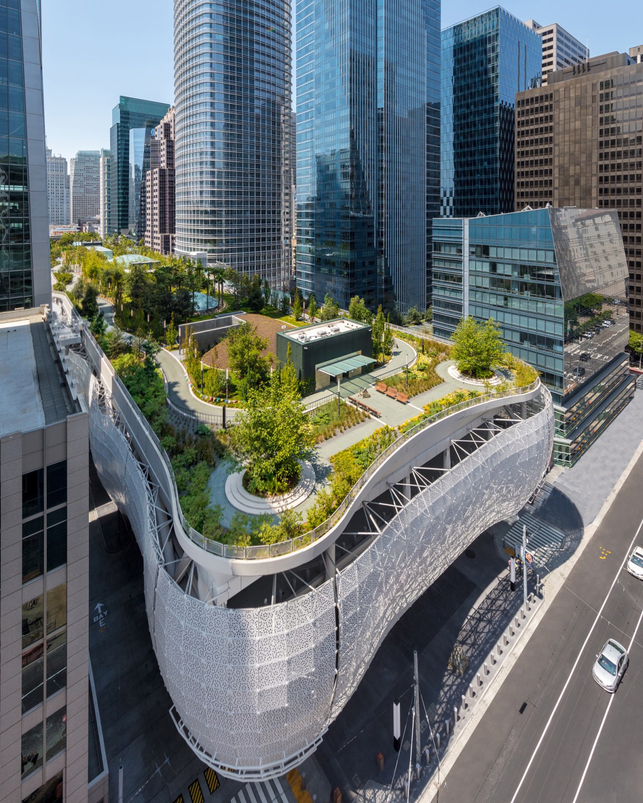 Aerial view of curved elevated park with gardens and walkways above a city street