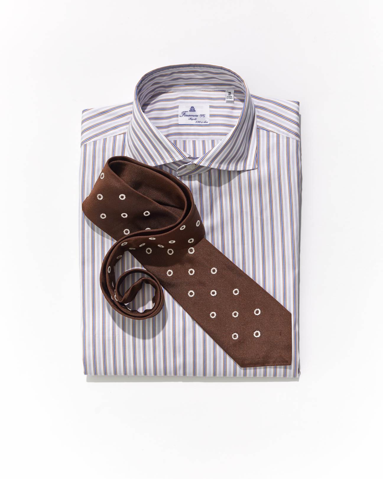 Brown patterned tie with white dots on striped dress shirt