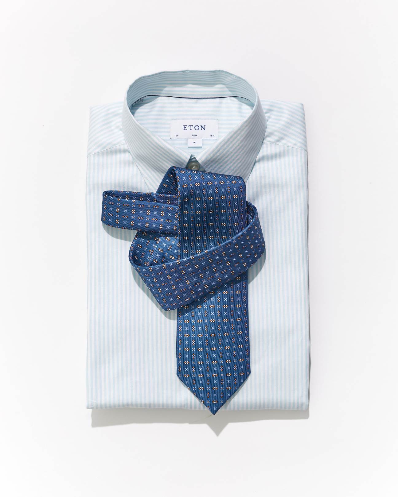 Blue patterned tie by E Marinella displayed on white striped Eton shirt