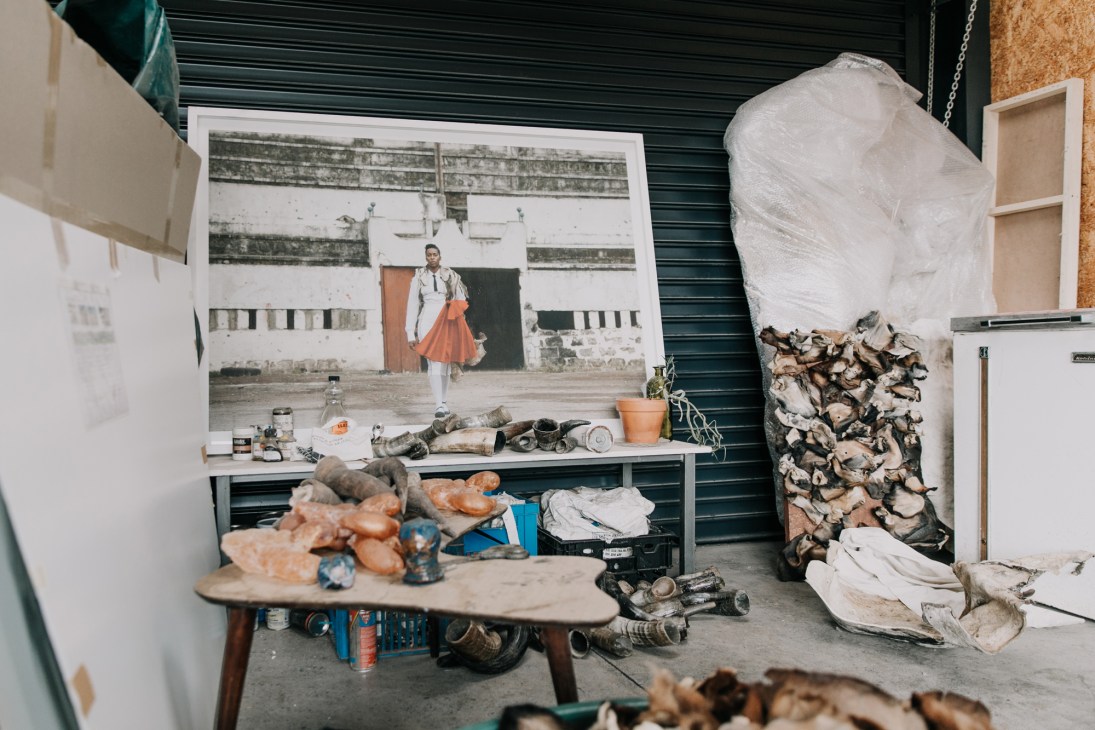 Artist's studio workspace with materials, canvases and work table in cluttered creative environment