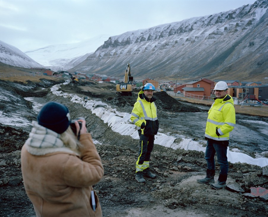 Reporter covering construction of avalanche protection barriers in Arctic town