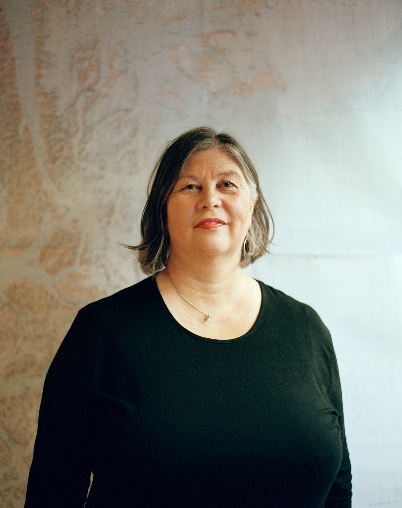 57-year-old woman at desk editing newspaper in Arctic office setting