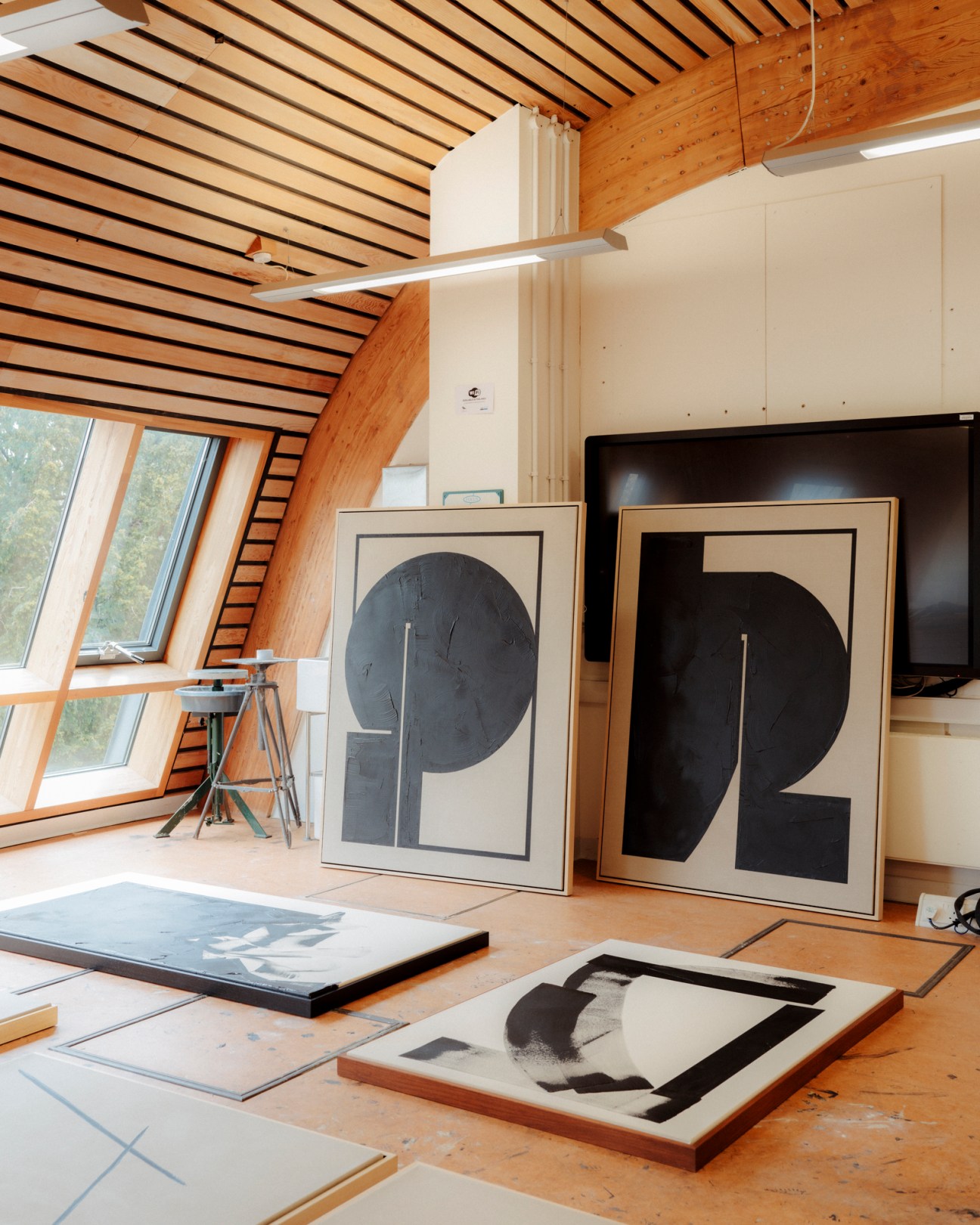Artist Tabitha Millett's studio with geometric black and white framed paintings on wooden floors.