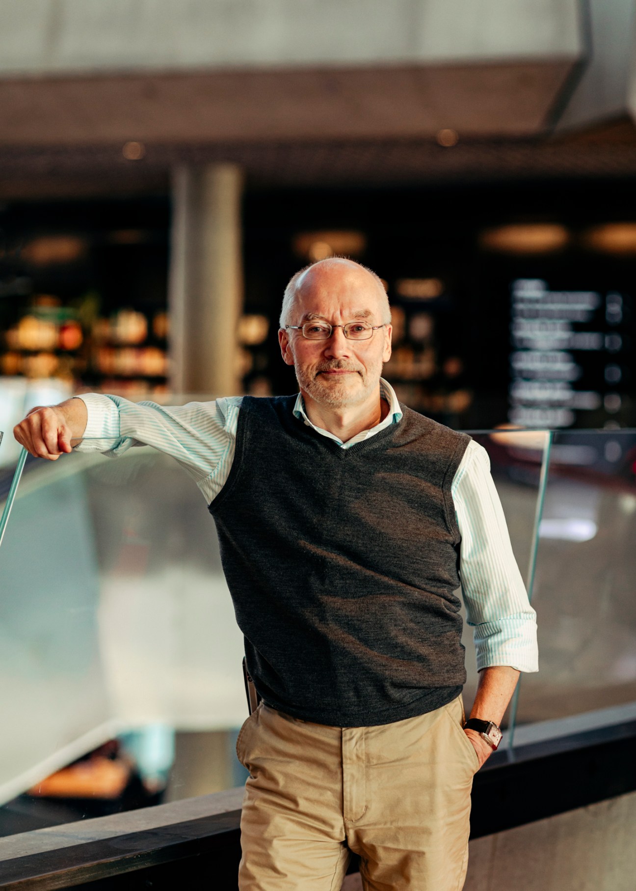 Knut Skansen, library director, standing in modern library interior with glass railings