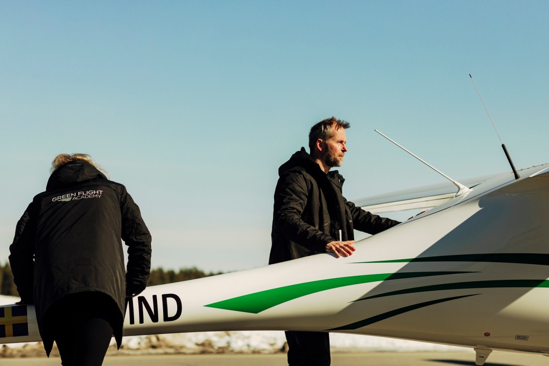 CEO Olov Hultdin standing beside white electric aircraft with green accents