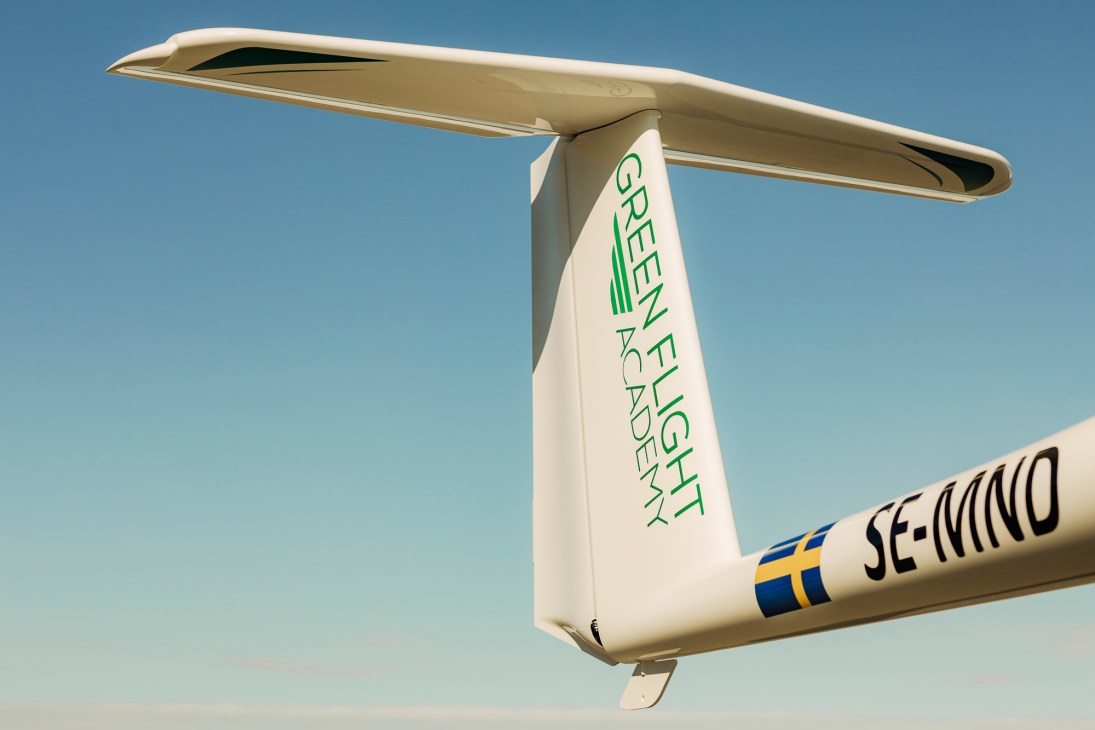 Close-up of white aircraft tail with Green Flight Academy logo and SE-WND registration