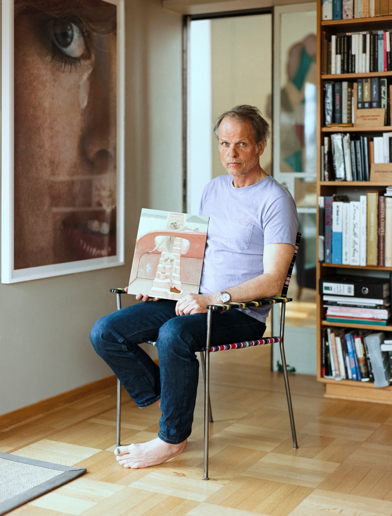 Erling Kagge holding a painting titled 'Ascending' by Anna Glantz in his home