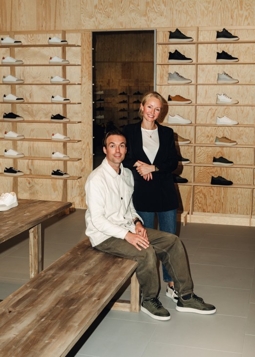 Martin Eversen and Ingrid Bolsøy holding New Movements sustainable trainers in their retail space