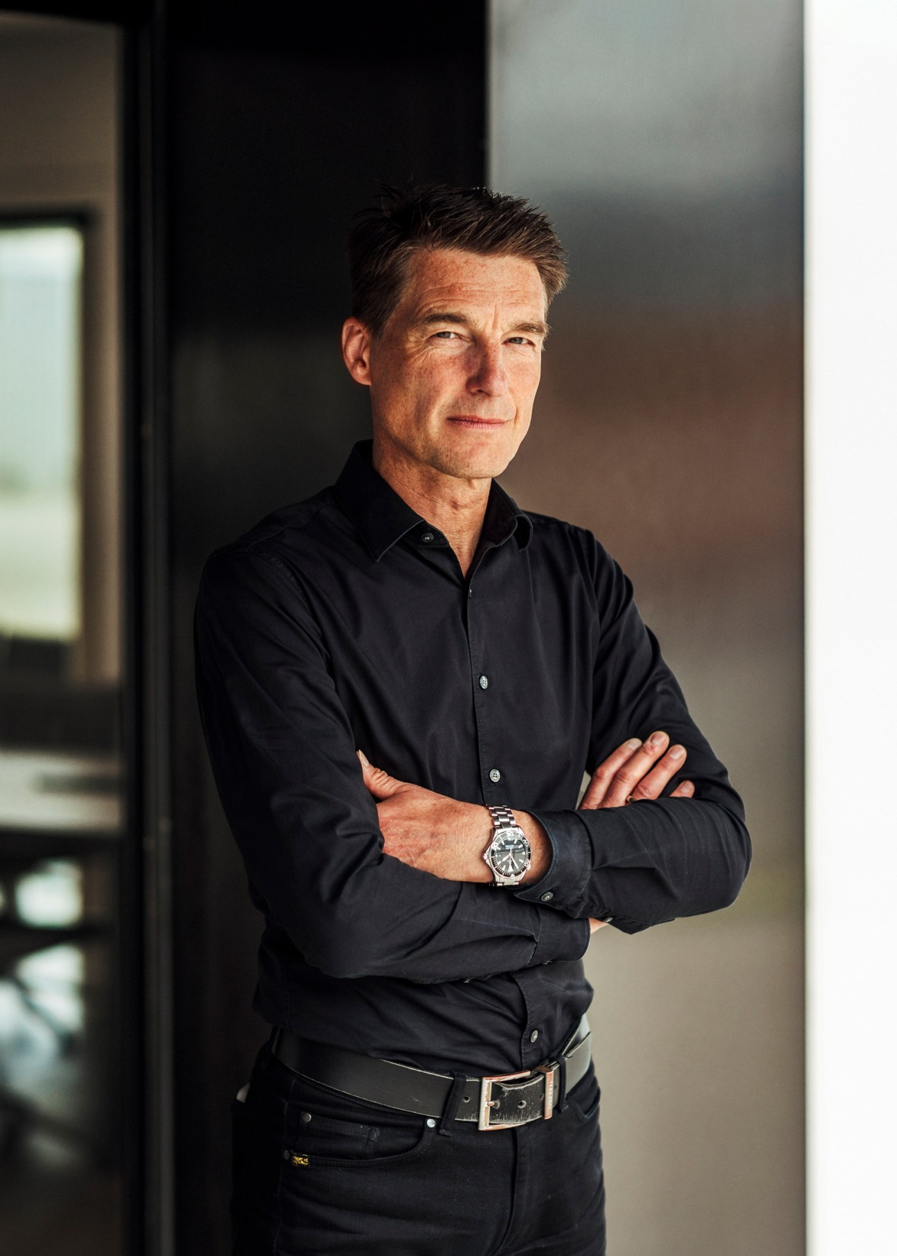 Thomas Ingenlath, Polestar CEO, in business attire standing in what appears to be a modern automotive facility