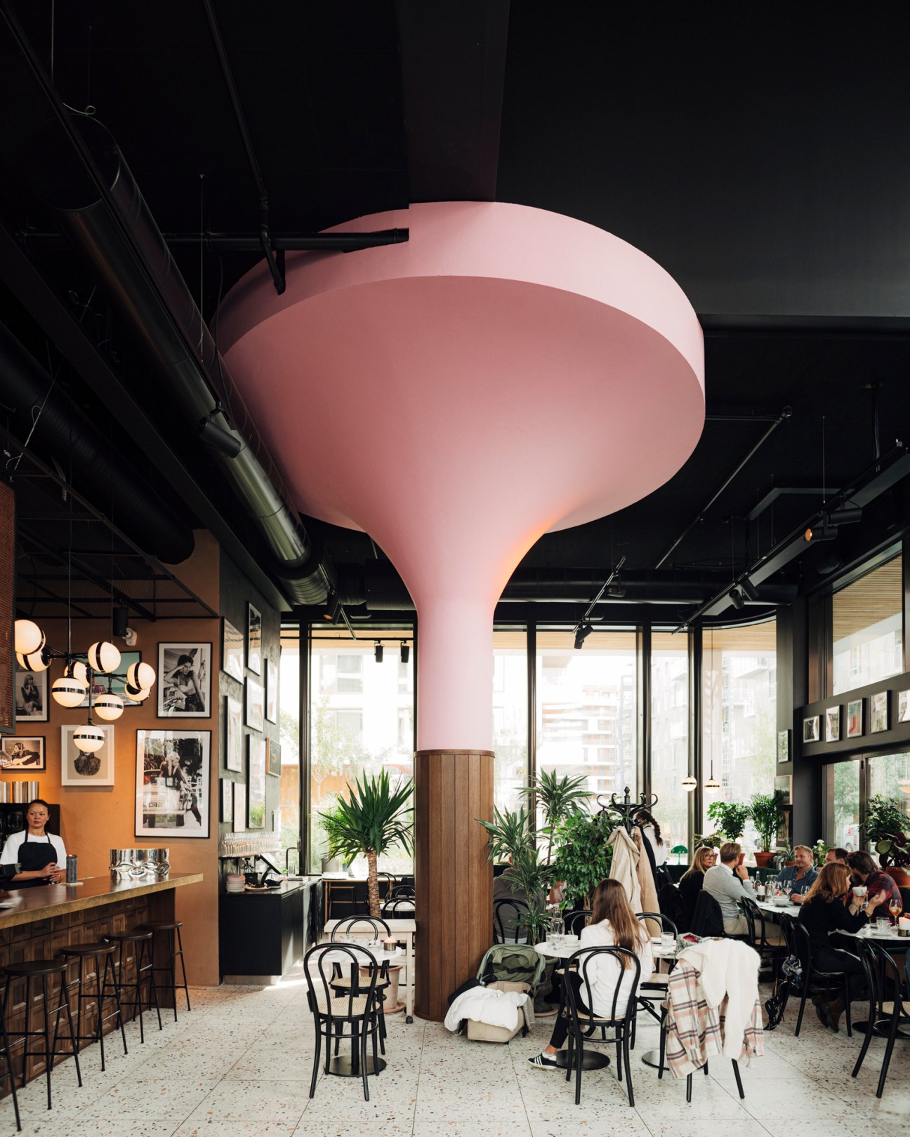The Vandelay restaurant interior in Oslo showing distinctive pink pillar and dining area with exposed ceiling
