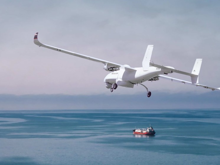 Tekever AR5 drone flying over ocean with small ship visible below
