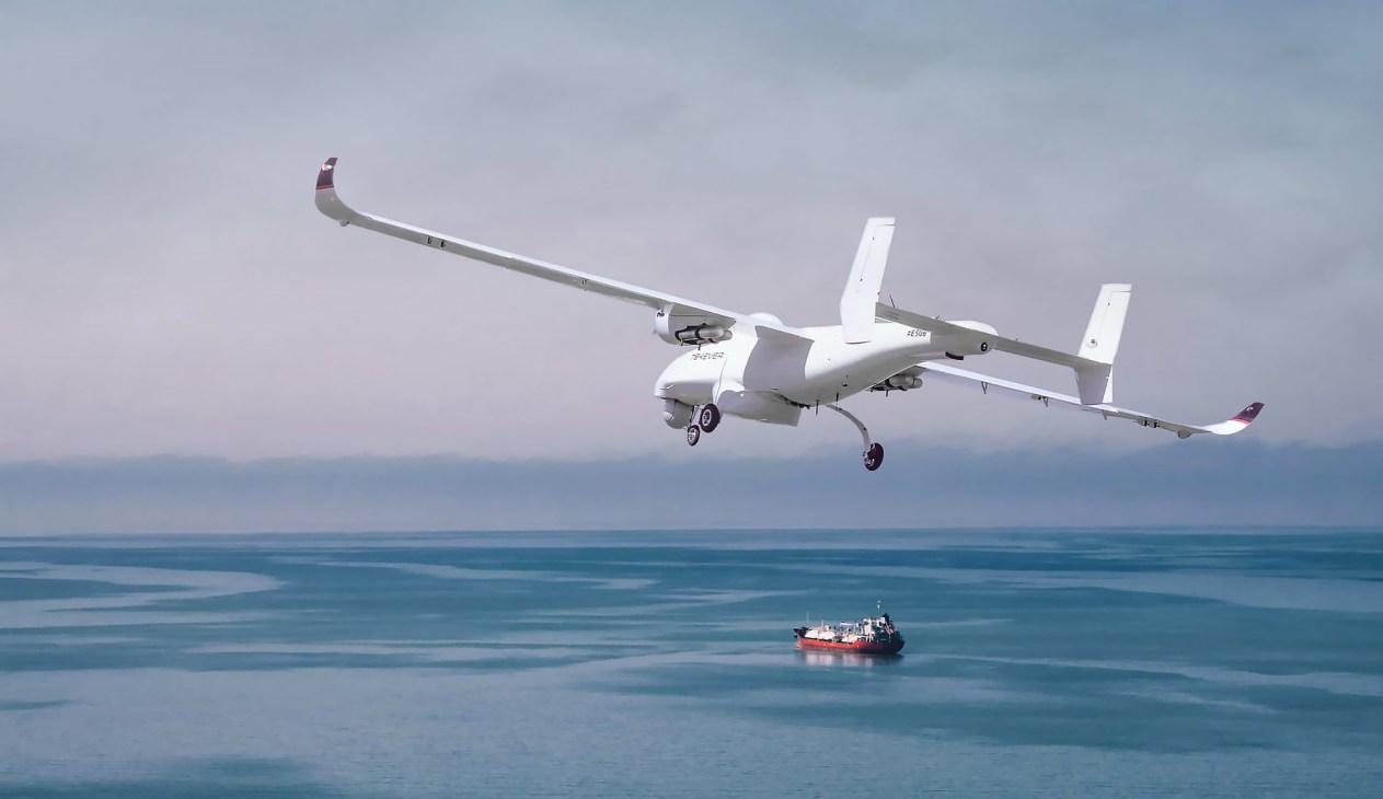 Tekever AR5 drone flying over ocean with small ship visible below