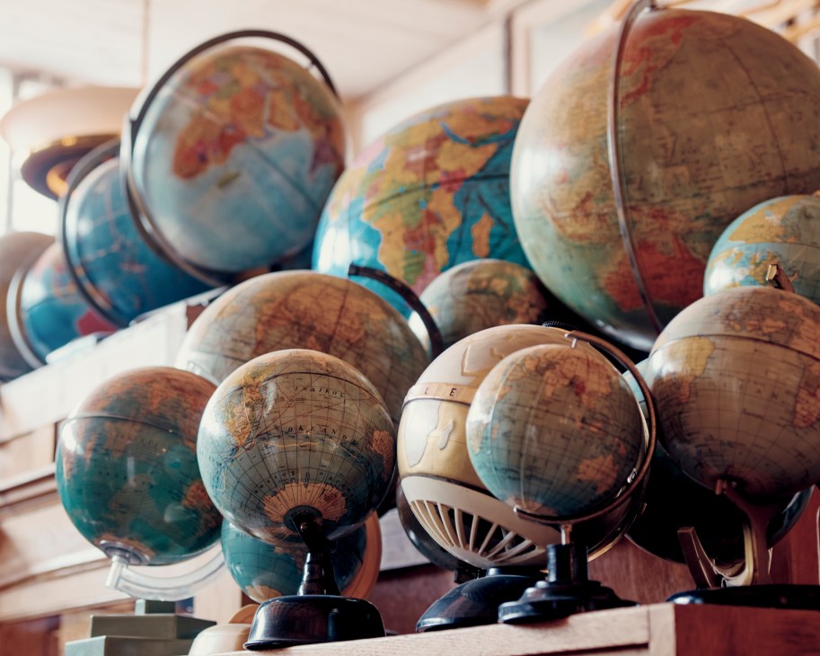 Multiple vintage globes of various sizes displayed together