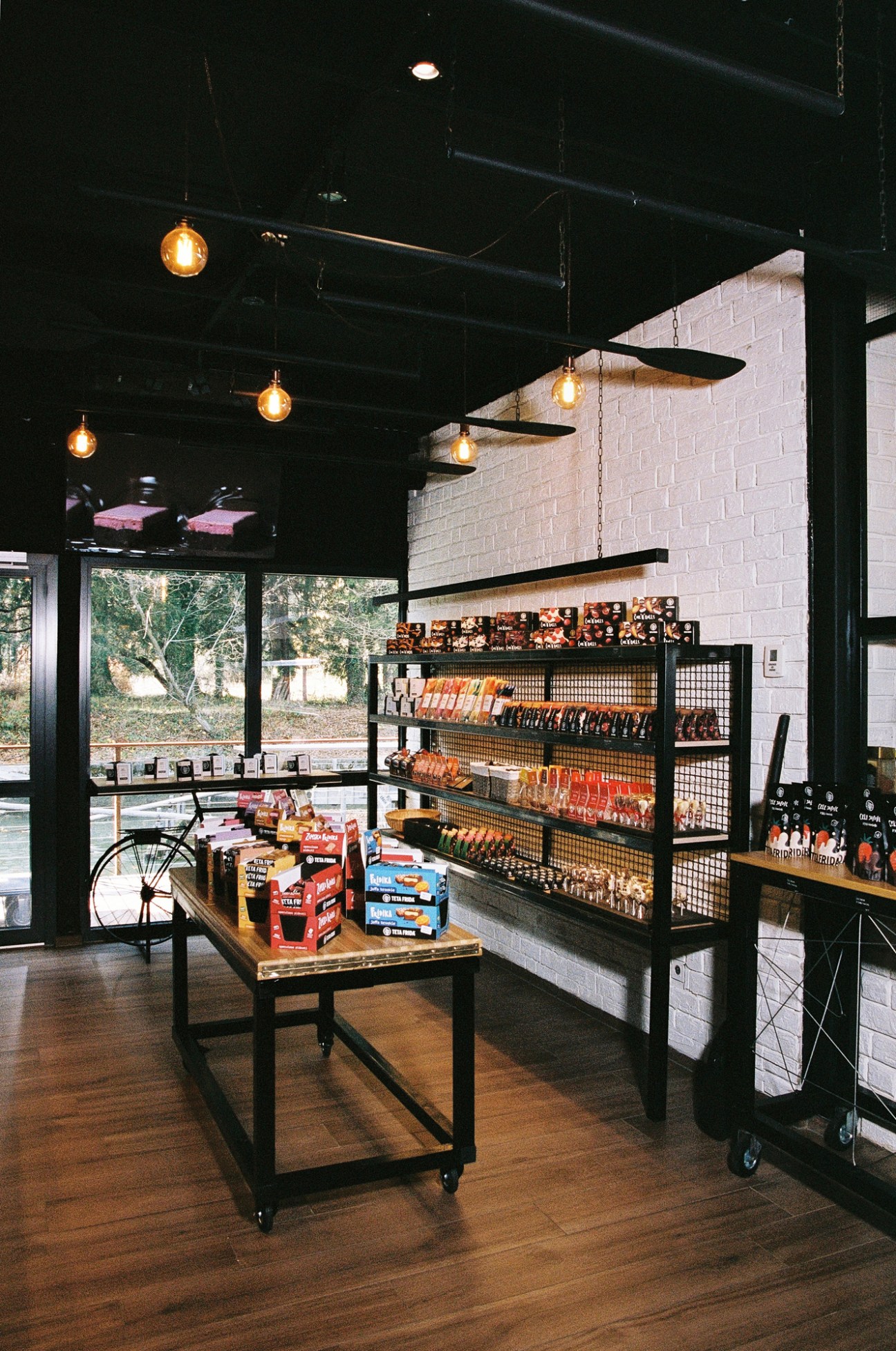 Interior of Teta Frida's Chocolate Village shop with shelving displaying chocolate products and vintage bicycle