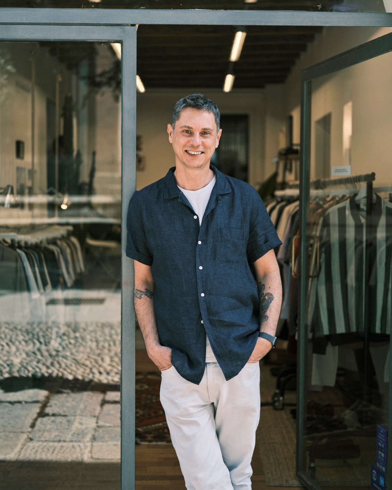 Matteo Rancilio, owner of Dictionary menswear shop in Milan, smiling at the entrance to his store.