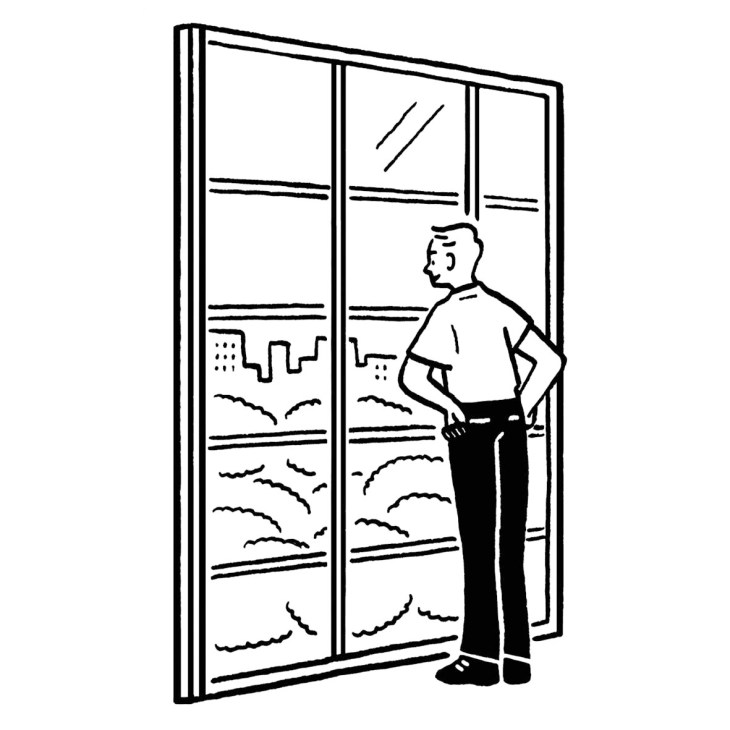 Man looking out a multi-pane window with city skyline visible outside