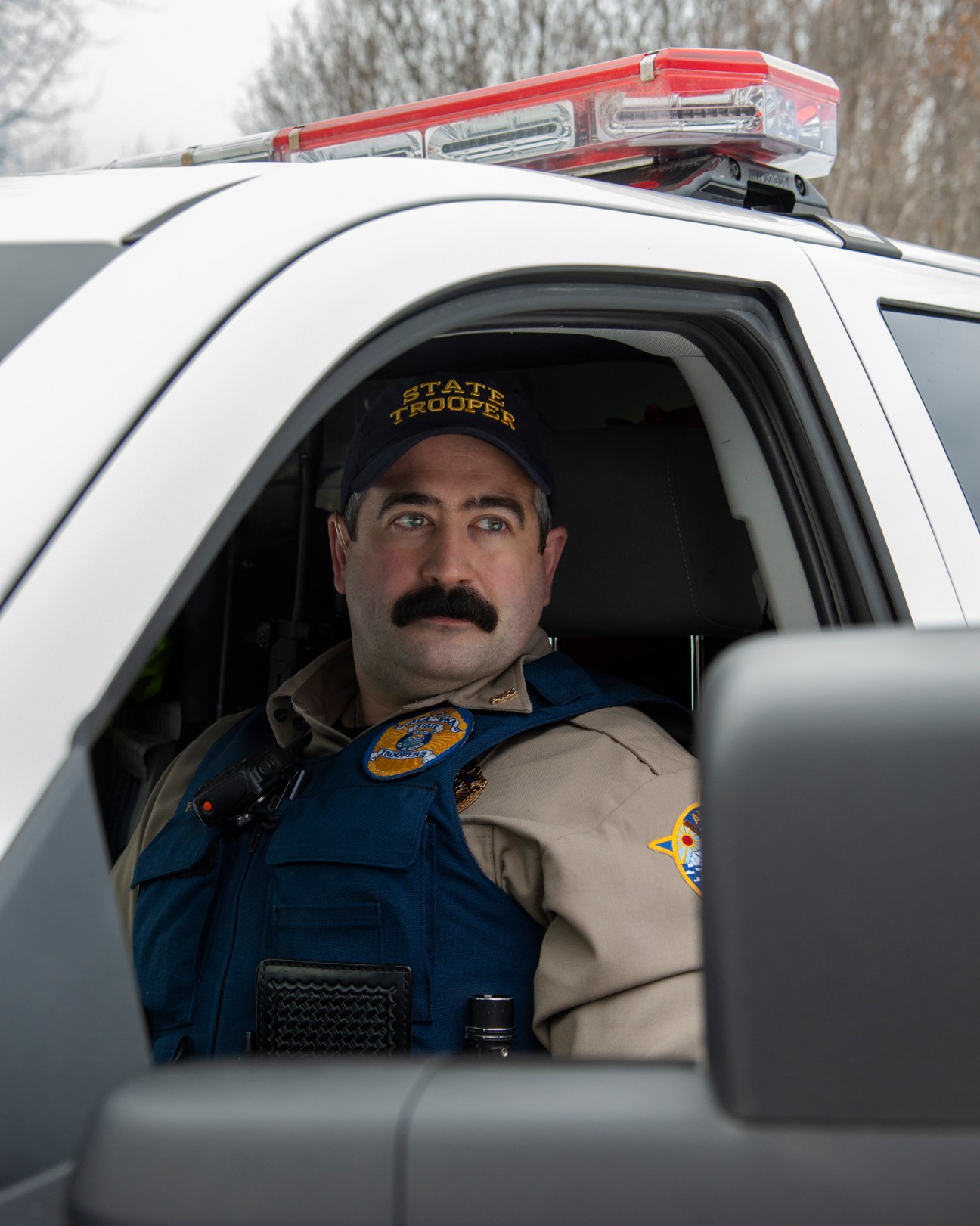 Wildlife trooper Patrick Simasko sitting in his Alaska State Troopers patrol vehicle