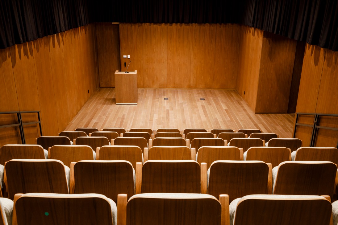 Interior of UAE Permanent Mission building showing wood-paneled walls, wooden seating area, and modern podium.