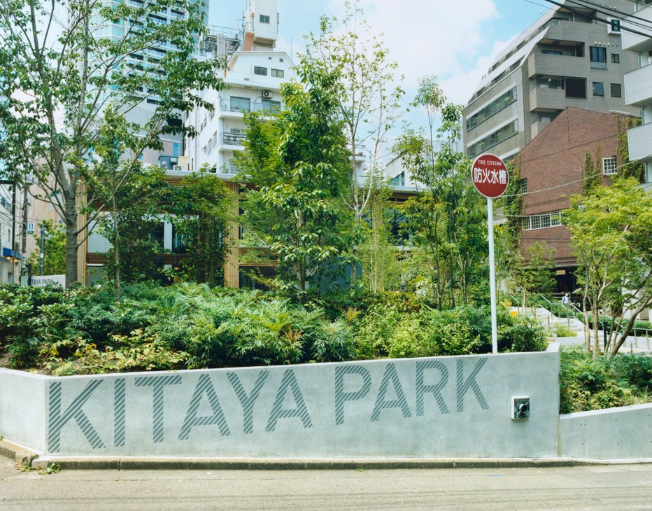 Kitaya Park entrance sign with lush green planting and surrounding Tokyo apartment buildings.