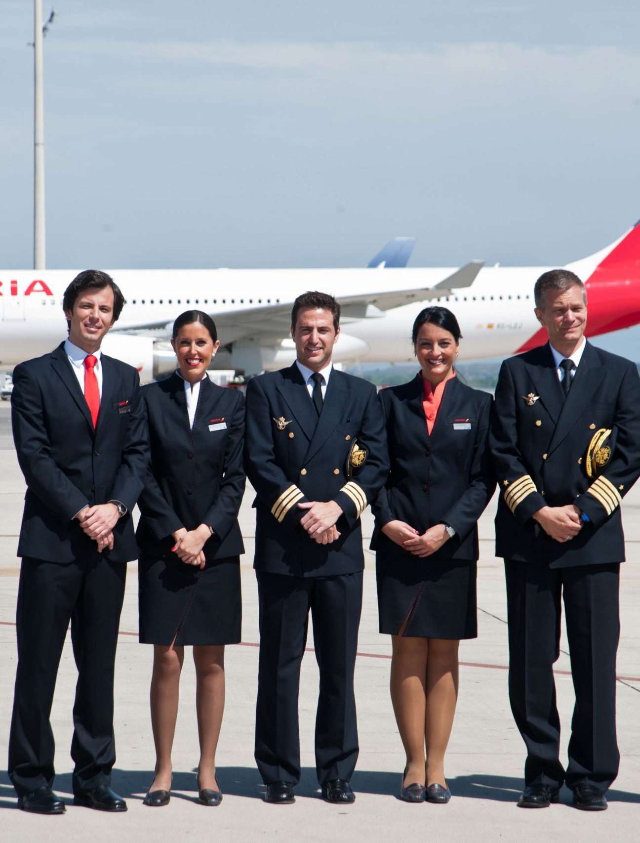 Five Iberia airline crew members in 2005 Adolfo Domínguez uniforms standing in front of aircraft