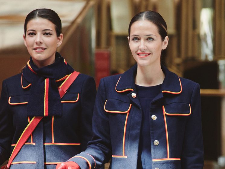 Two female Iberia Airlines crew members wearing Teresa Helbig's new navy uniform designs with red and yellow trim