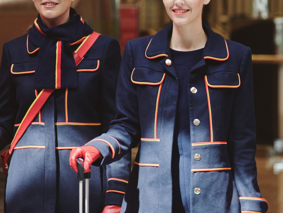 Two female Iberia Airlines crew members wearing Teresa Helbig's new navy uniform designs with red and yellow trim