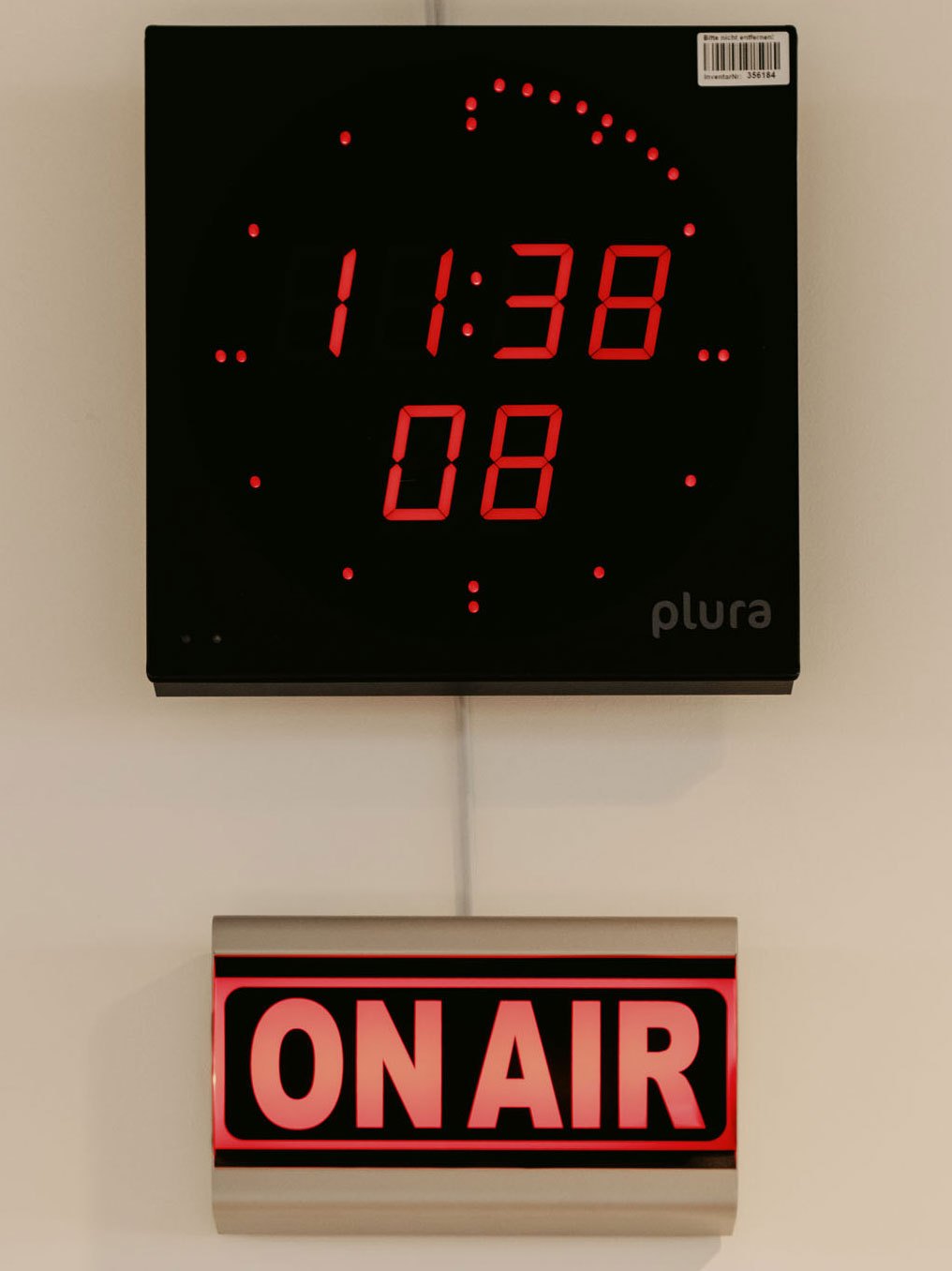 Digital clock display showing 11:38 and 08 with red LED numbers above illuminated ON AIR sign