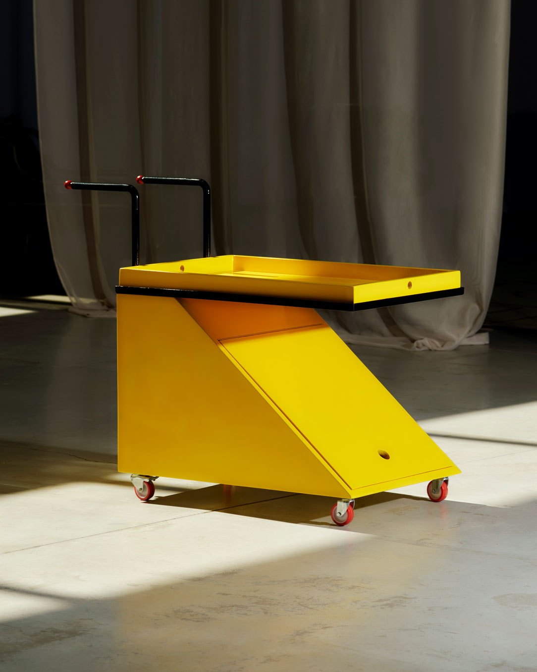 Yellow angular Carolino bar trolley by Older studio featuring geometric design with black handle and wheels