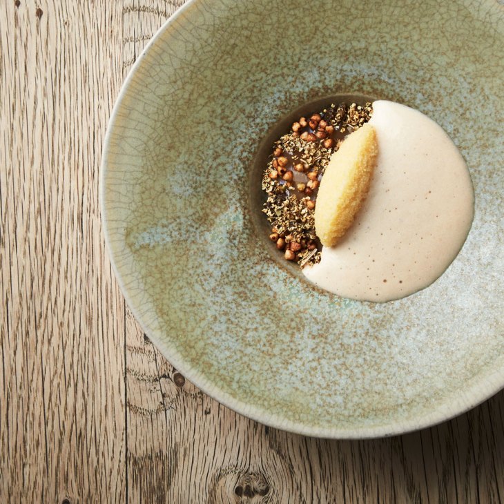 Elegantly plated dish featuring Arctic crab with elderflower, buckwheat, and capelin roe on artisanal ceramic