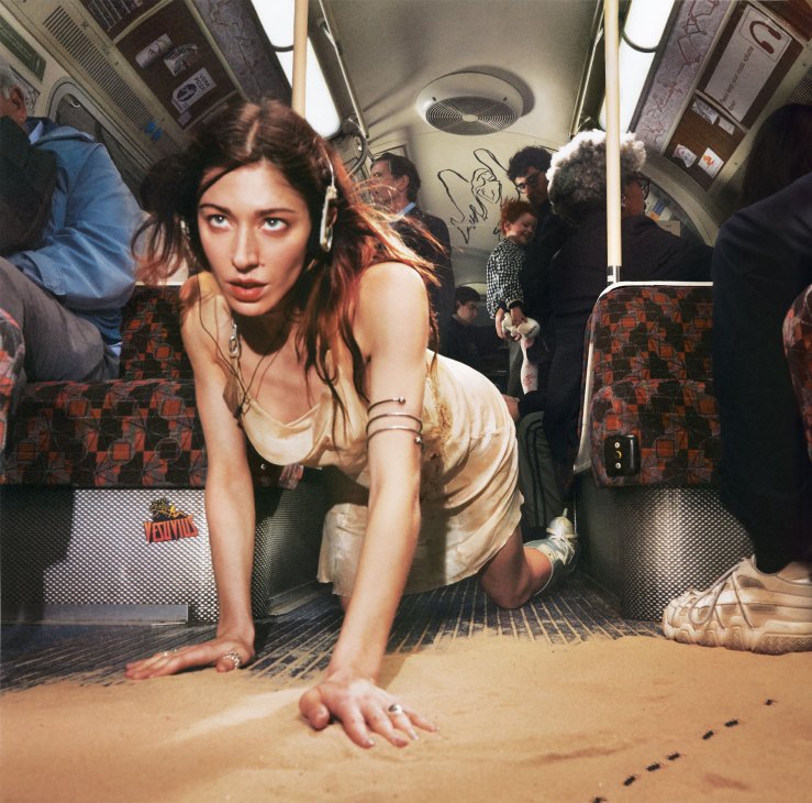 Album cover for Caroline Polachek's 'Desire, I Want to Turn into You' showing a woman crawling in what appears to be a train car