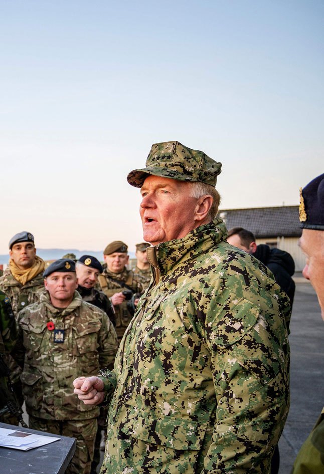 Admiral James Foggo in naval uniform standing outdoors with military personnel in background