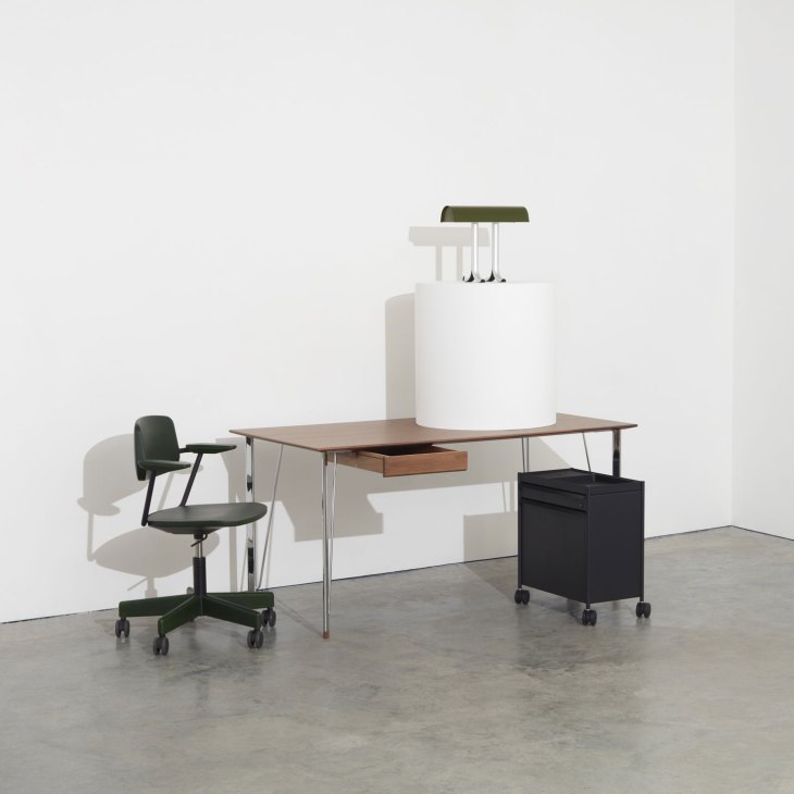 Modern office furniture including wooden desk chair, writing desk and table lamp in minimalist setting