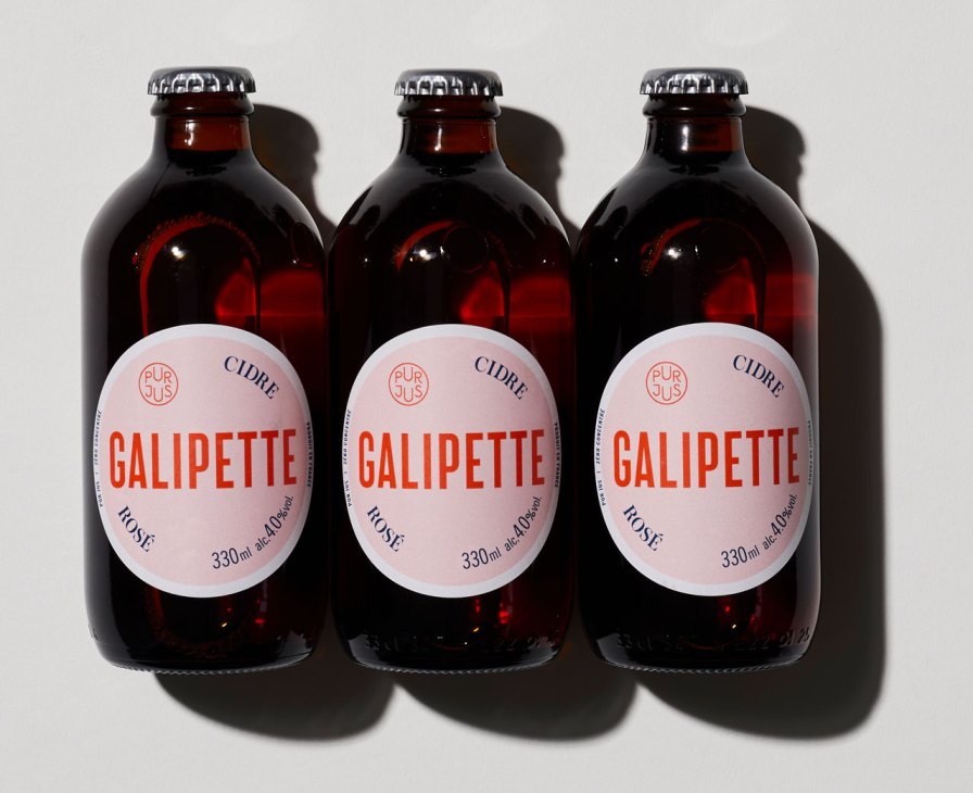 Three dark glass bottles of Galipette rosé cider with pink and white labels