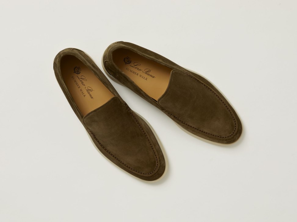 Pair of olive green suede loafers with tan leather insoles on light background