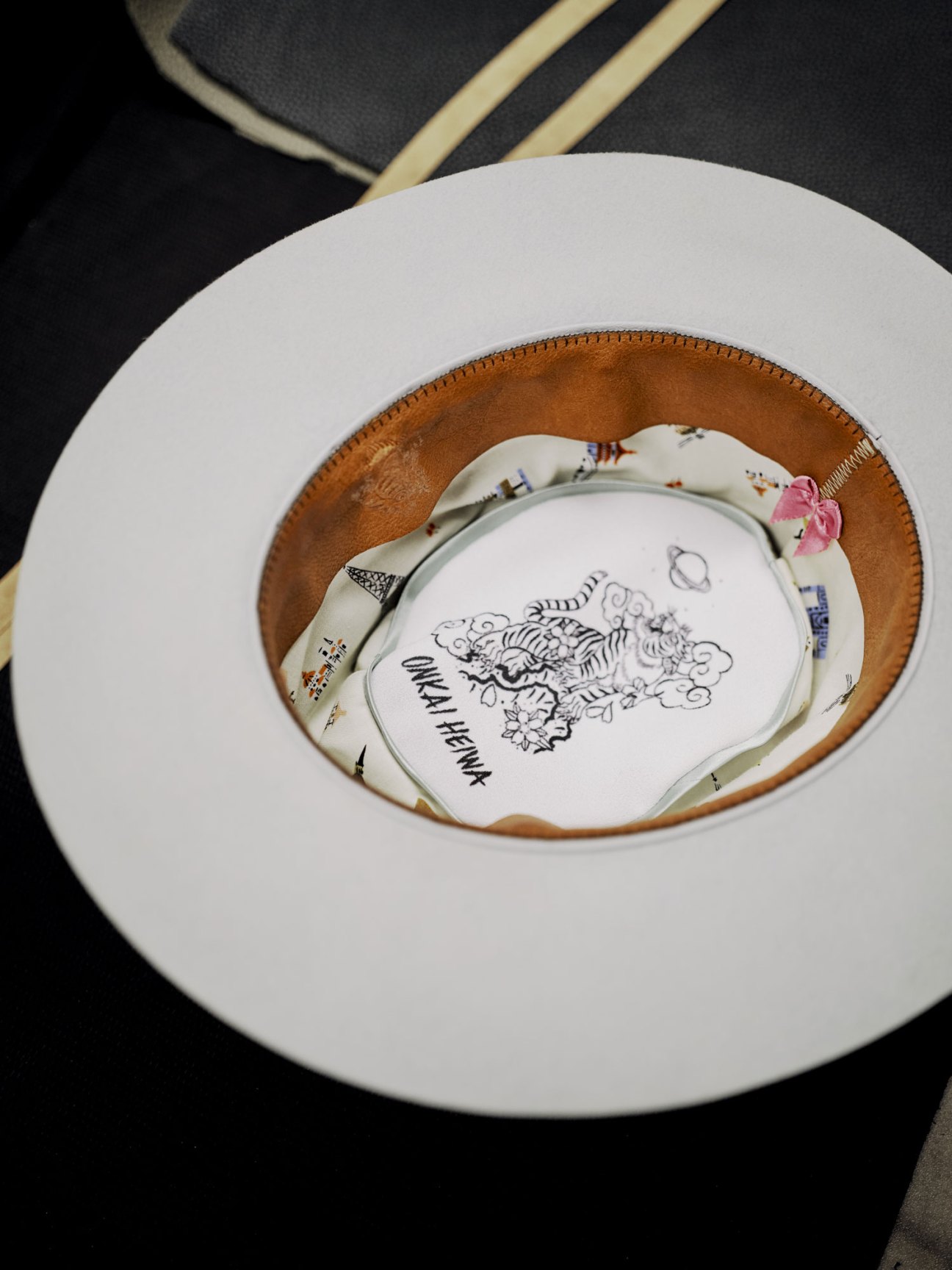 White felt fedora hat by Onkai Heiwa displayed from above with interior label visible.