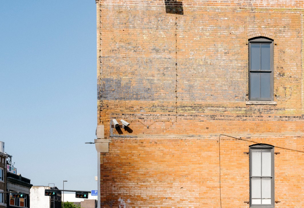 Weathered brick building wall with faded painted signage in downtown Dallas